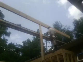 Carpenter setting a ridge beam over a new addition frame — Ice Dam Removal by Roofing Brothers in Ellicottville