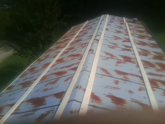 Rusted metal roof panels with new wood purlins before replacement — Storm Damage Roof Repair in Ellicottville by Roofing Brothers
